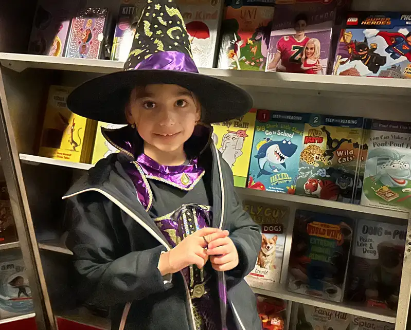 child dressed as a wizard in library